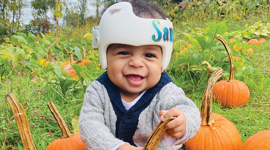 Baby in a doc band at a pumpkin patch