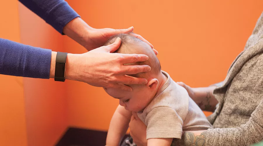 Baby getting a head shape assessment from a clinician